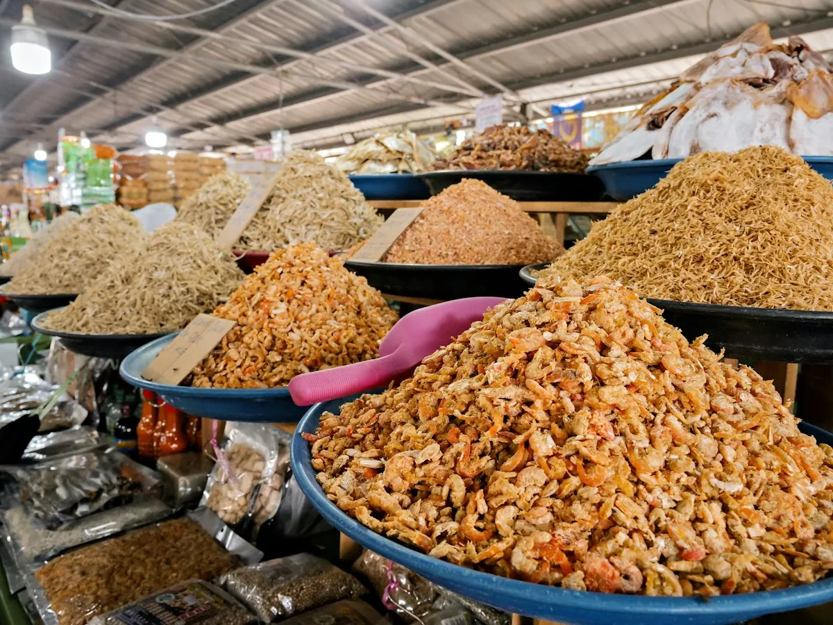 Heaped trays of dried shrimp and small dried fish on a market stall